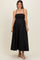 woman wearing a black maternity maxi dress with thin straps and a fitted bodice, showing her baby bump