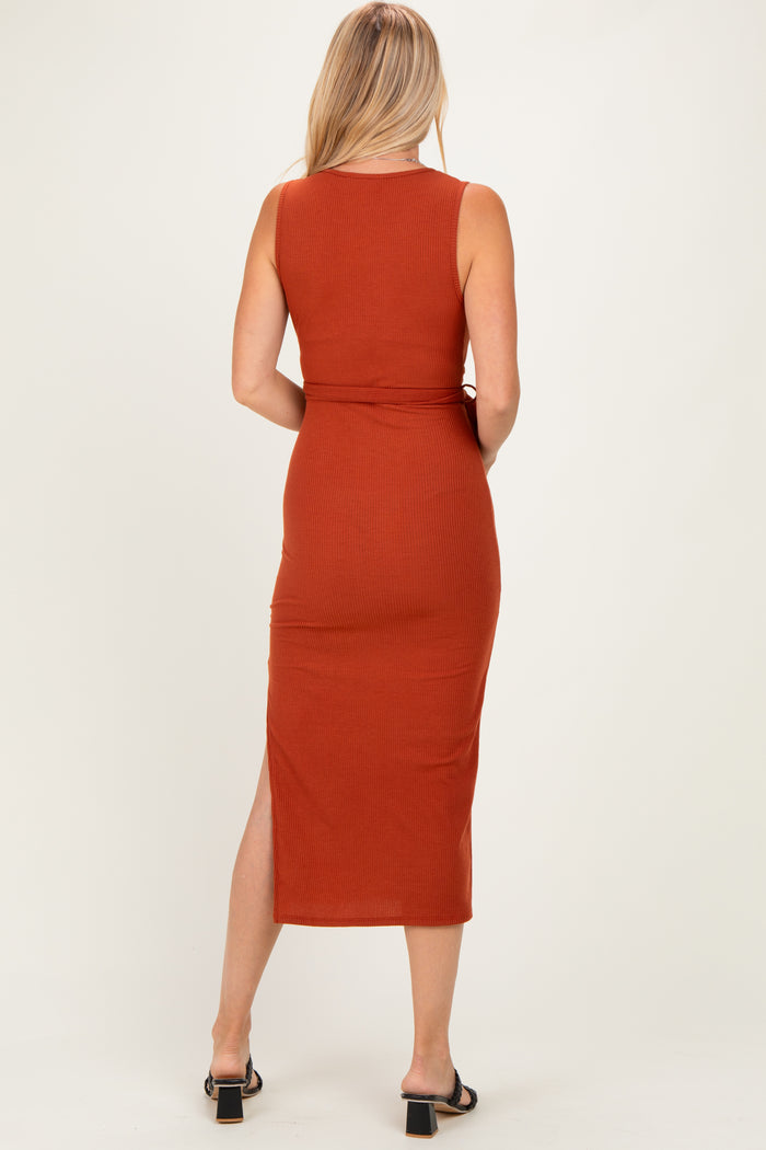 woman wearing a rust-colored sleeveless maxi dress with a side slit, shown from the back