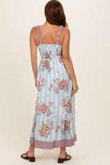 woman wearing a light blue floral maxi dress with smocked bodice and tiered skirt, viewed from the back