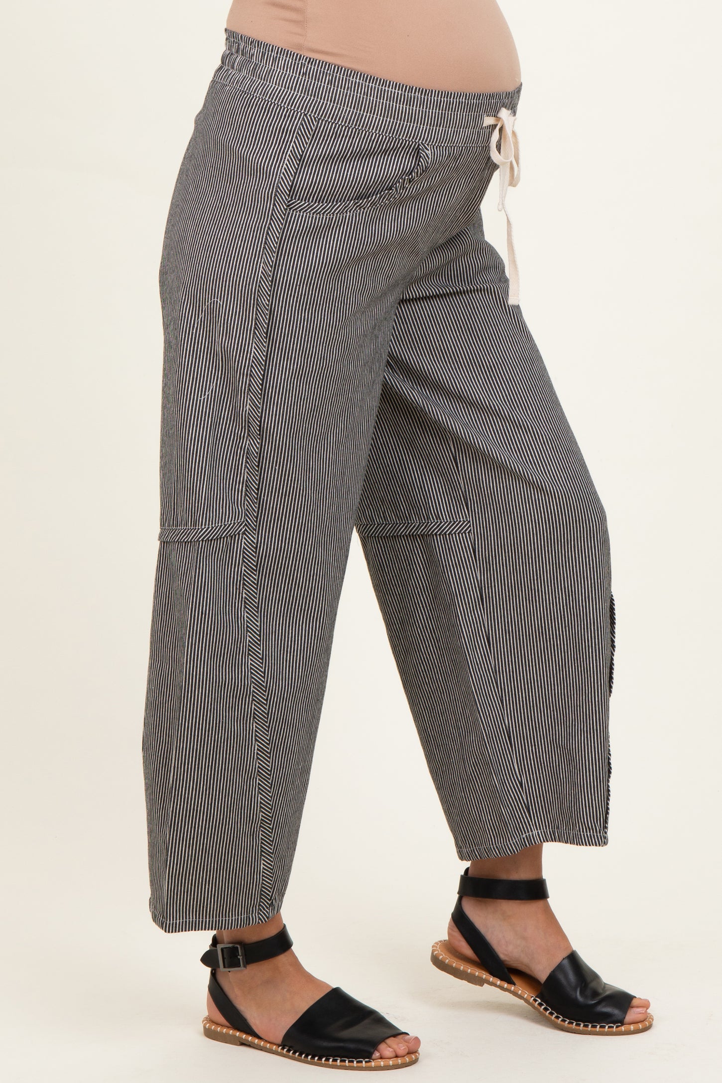 woman wearing black and white striped maternity wide-leg pants with a drawstring waist and visible baby bump