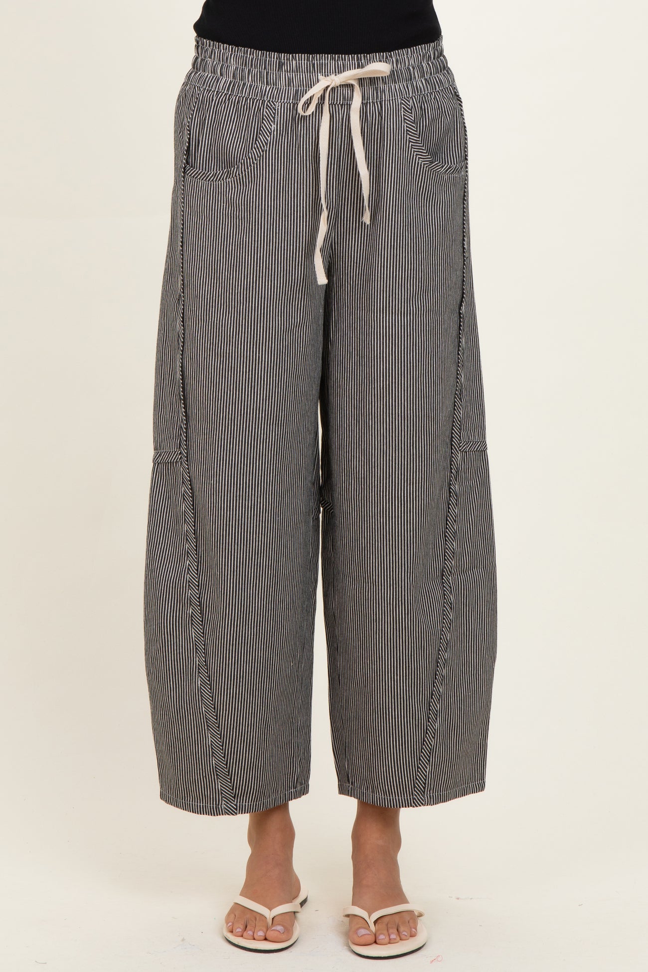 woman wearing black and white striped wide-leg pants with an elastic waistband and drawstring detail