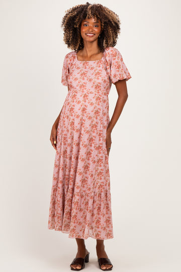 woman wearing a pink floral maternity maxi dress with short sleeves and a square neckline showing her baby bump