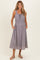woman wearing a gray striped maternity dress with a smocked waist and pockets, styled with sandals