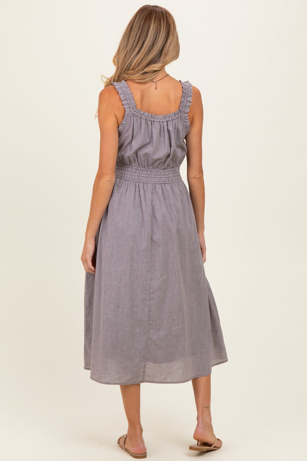 woman wearing a gray striped maternity dress with ruffled straps and a smocked waist, view from the back
