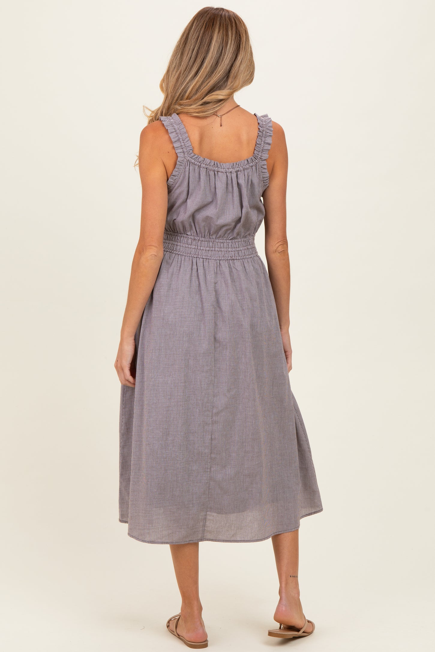 woman wearing a gray striped maternity dress with ruffled straps and a smocked waist, view from the back