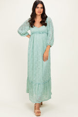 woman wearing a light mint green maxi dress with puff sleeves and a ruffled hem