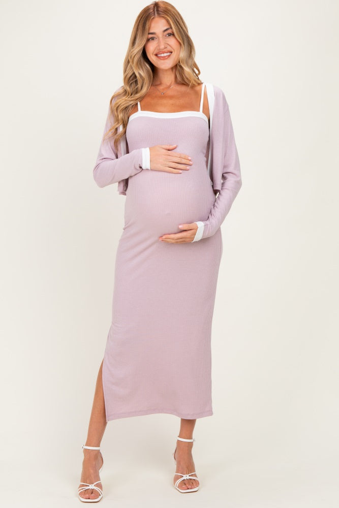 woman wearing a lavender ribbed maternity dress with side slits and a white trim, holding her baby bump