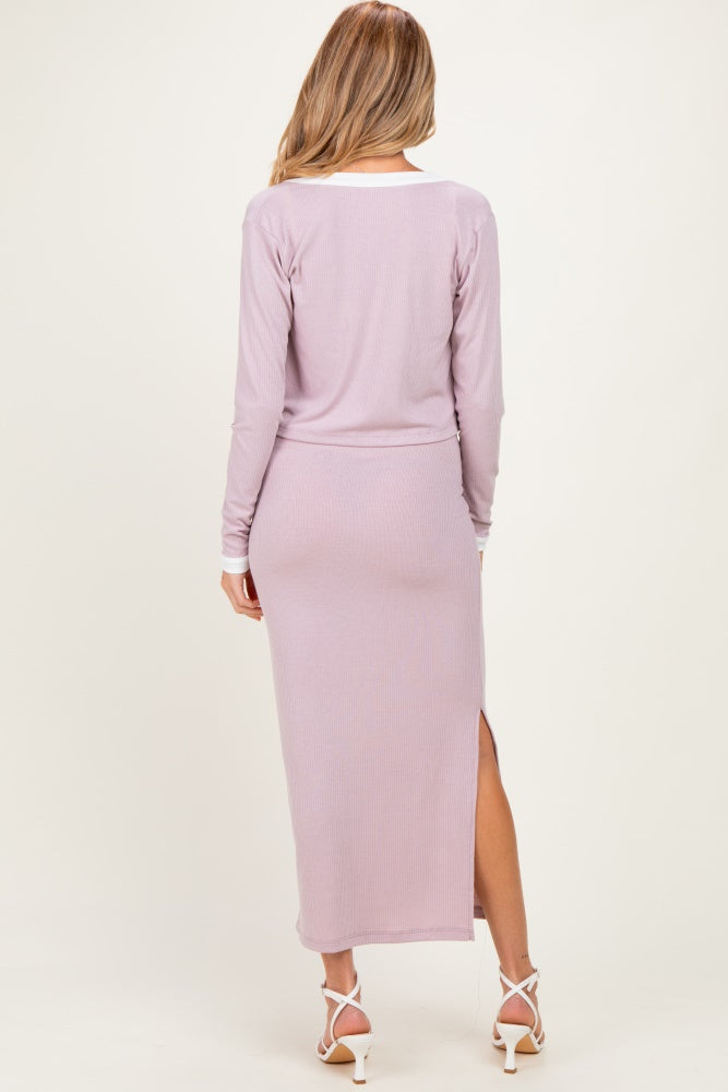 woman wearing a lavender long sleeve maternity dress with a side split, showing her back and hair down