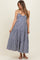 woman wearing a navy blue and white gingham print maternity dress with spaghetti straps and tiered skirt