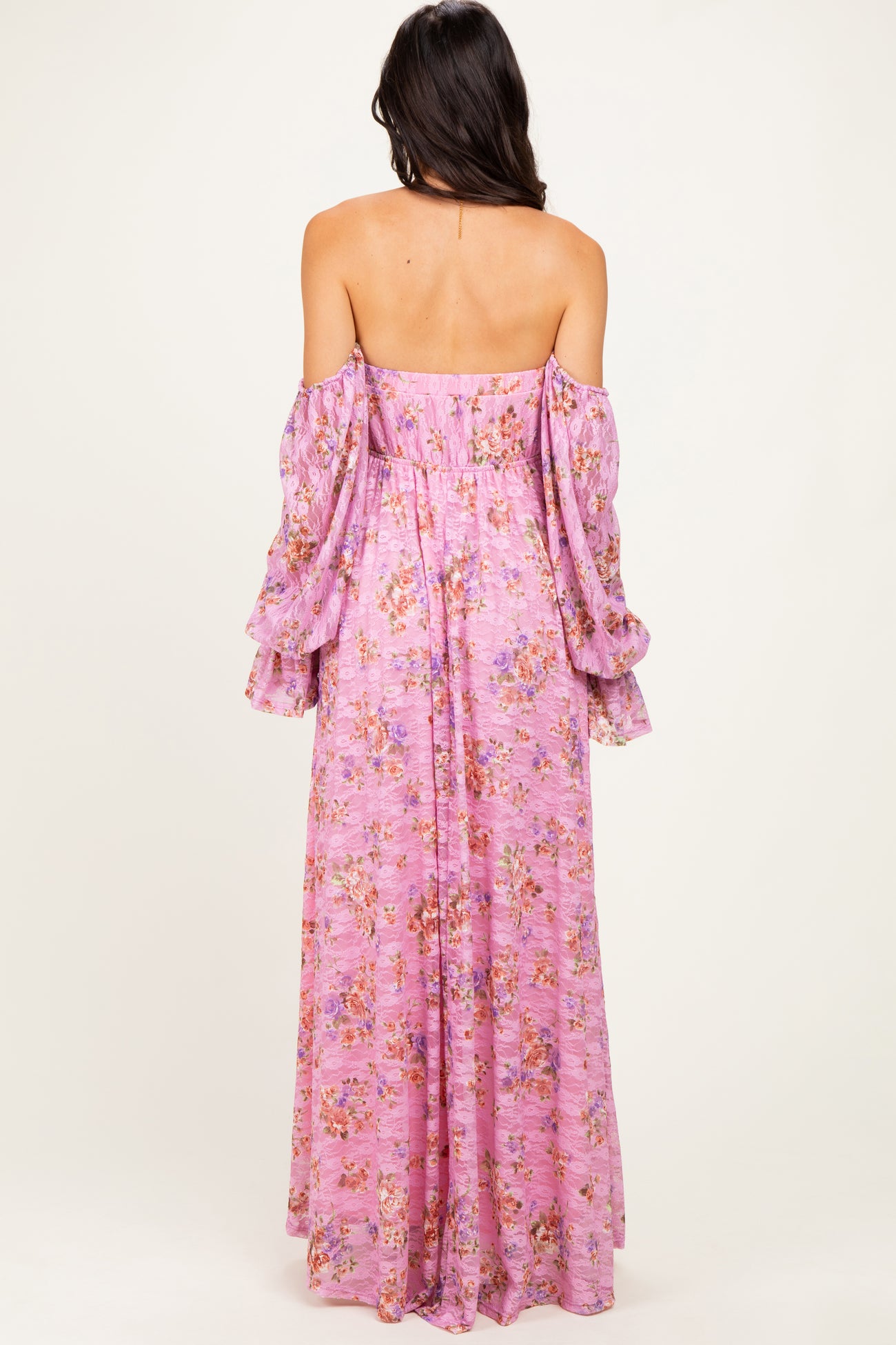 woman wearing a pink floral off-the-shoulder maxi dress with bell sleeves, seen from the back