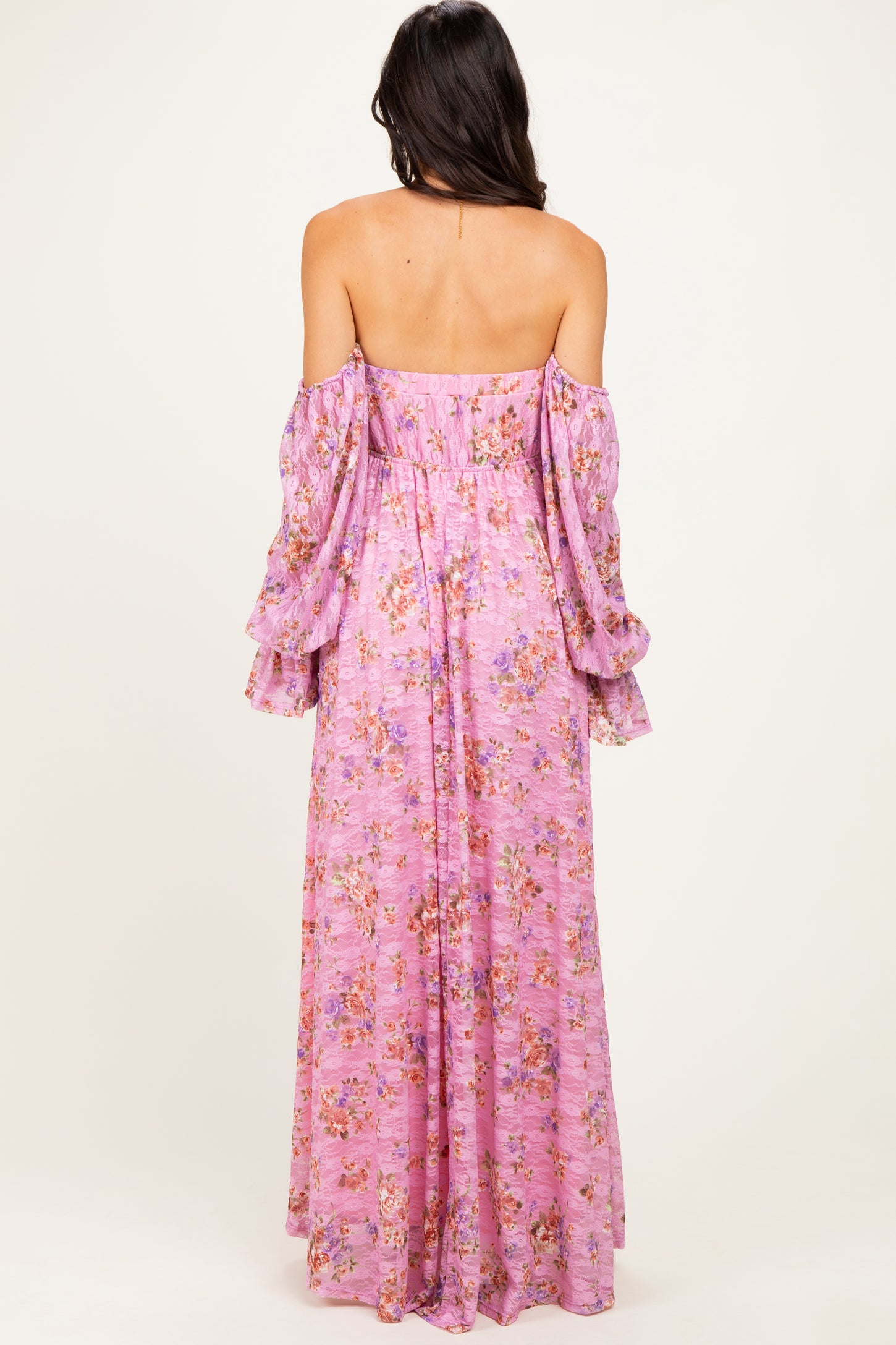 woman wearing a pink floral off-the-shoulder maxi dress with bell sleeves, seen from the back