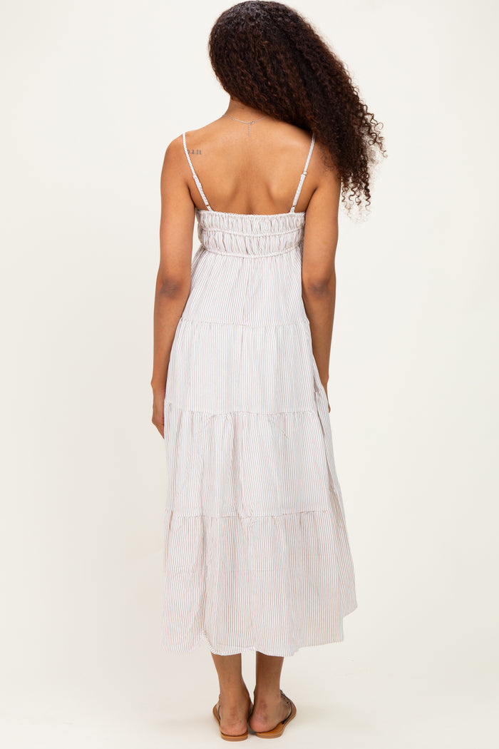 woman wearing a striped tiered maxi dress with adjustable spaghetti straps, view from the back