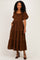woman wearing a brown puff sleeve maxi dress with tiered layers and pockets