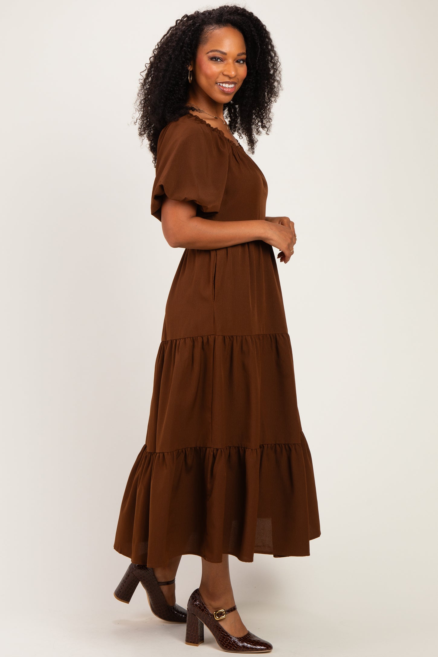 woman wearing a brown tiered maxi dress with short puff sleeves and a relaxed fit