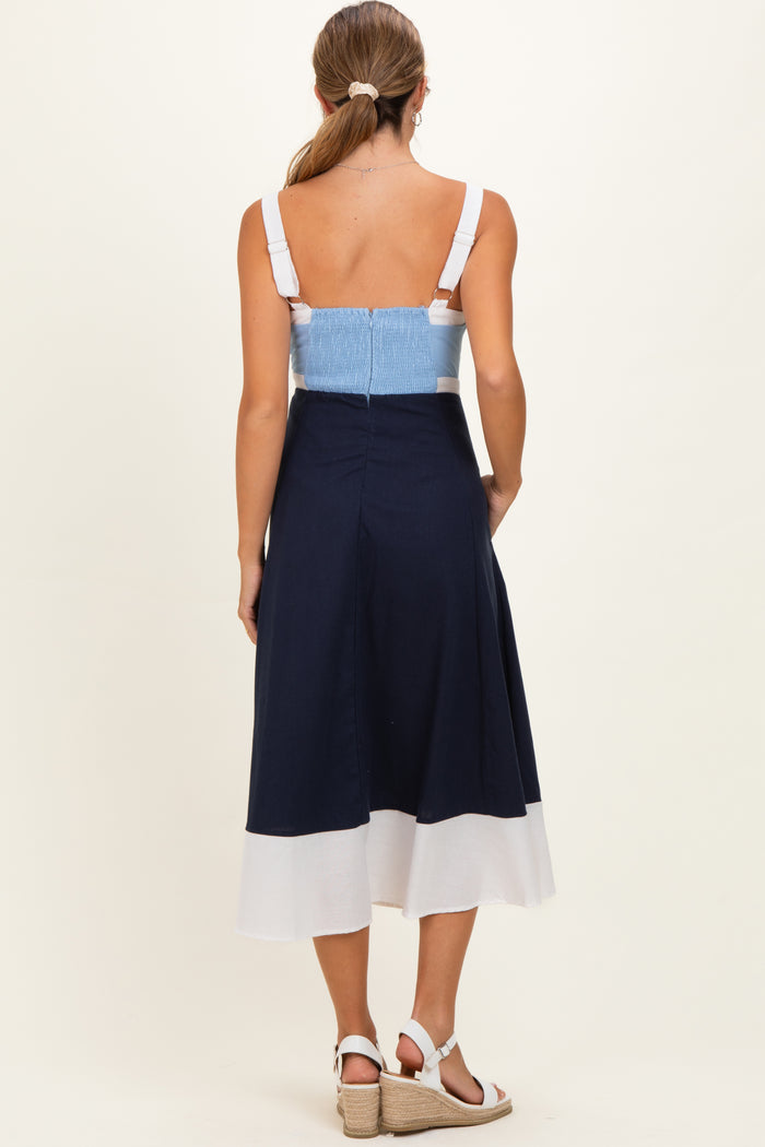 woman wearing a navy and white colorblock maternity dress with a smocked bodice, showing her back