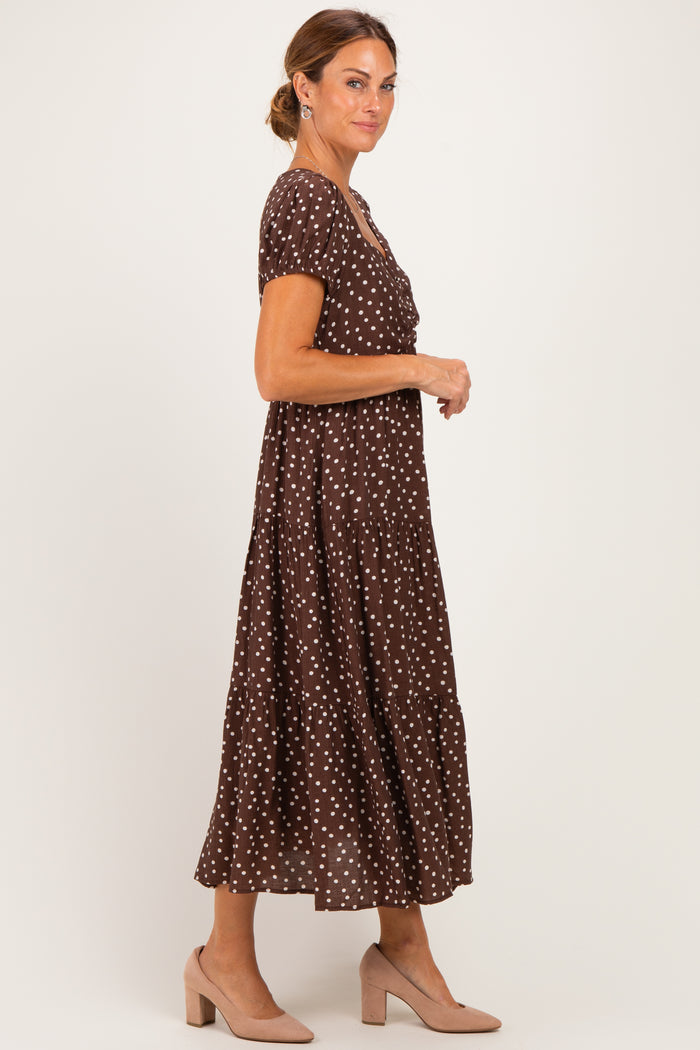 woman wearing a brown polka dot maxi dress with short sleeves and a tiered skirt, styled with nude heels