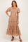 woman wearing a beige puff sleeve maxi dress with a smocked bodice and tiered tulle skirt
