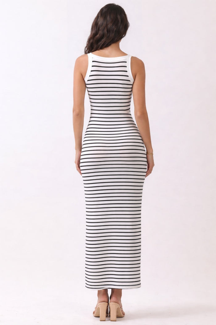 woman wearing a fitted white and navy striped maxi dress, view from the back