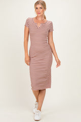 woman wearing a striped midi dress with a scoop neck and short sleeves, styled with white sneakers