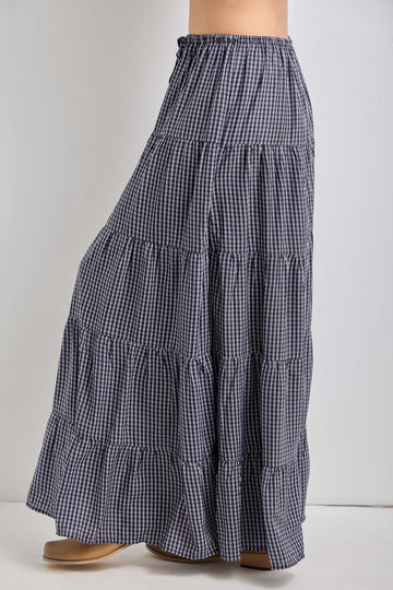 woman wearing a navy and white gingham tiered maxi skirt with an elastic waistband