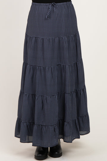 woman wearing a navy and white checked maternity maxi skirt with tiered ruffles and an elastic waistband