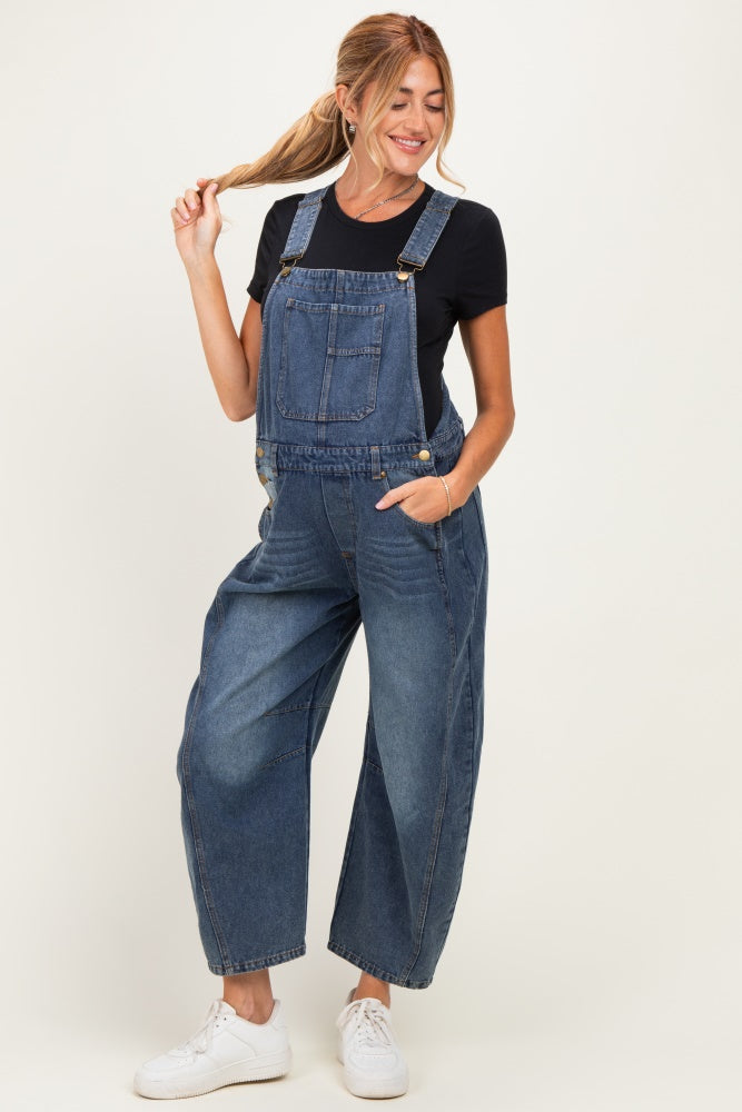 woman wearing a black t-shirt and denim maternity overalls with loose fit and pockets, styled casually