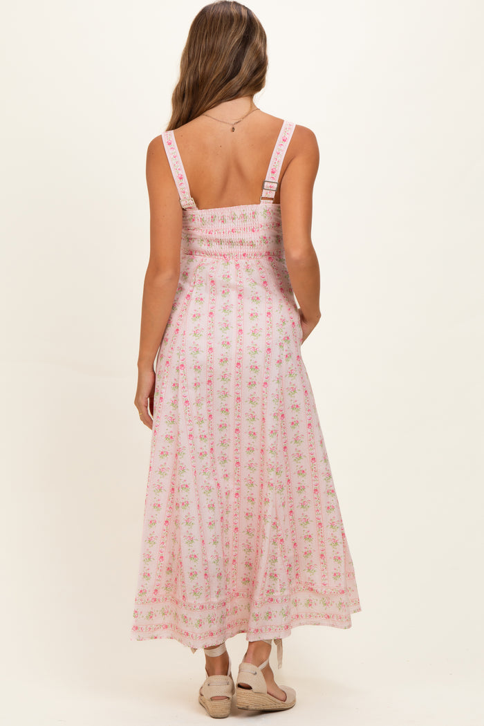 woman wearing a pink floral maternity maxi dress with smocked bodice and adjustable straps
