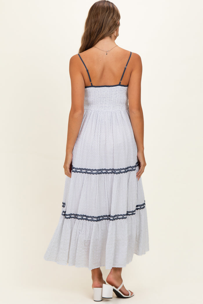 woman wearing a white maternity maxi dress with navy lace details and thin straps, showcasing a comfortable fit