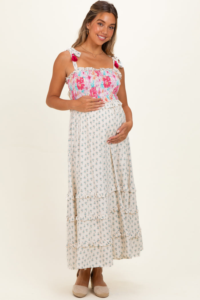 woman wearing a floral maternity maxi dress with tie straps, crisscross bodice, and baby bump visible