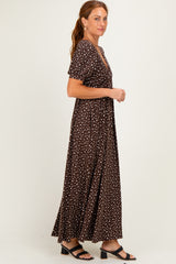 woman wearing a brown maxi dress with white polka dots and short sleeves, standing in profile