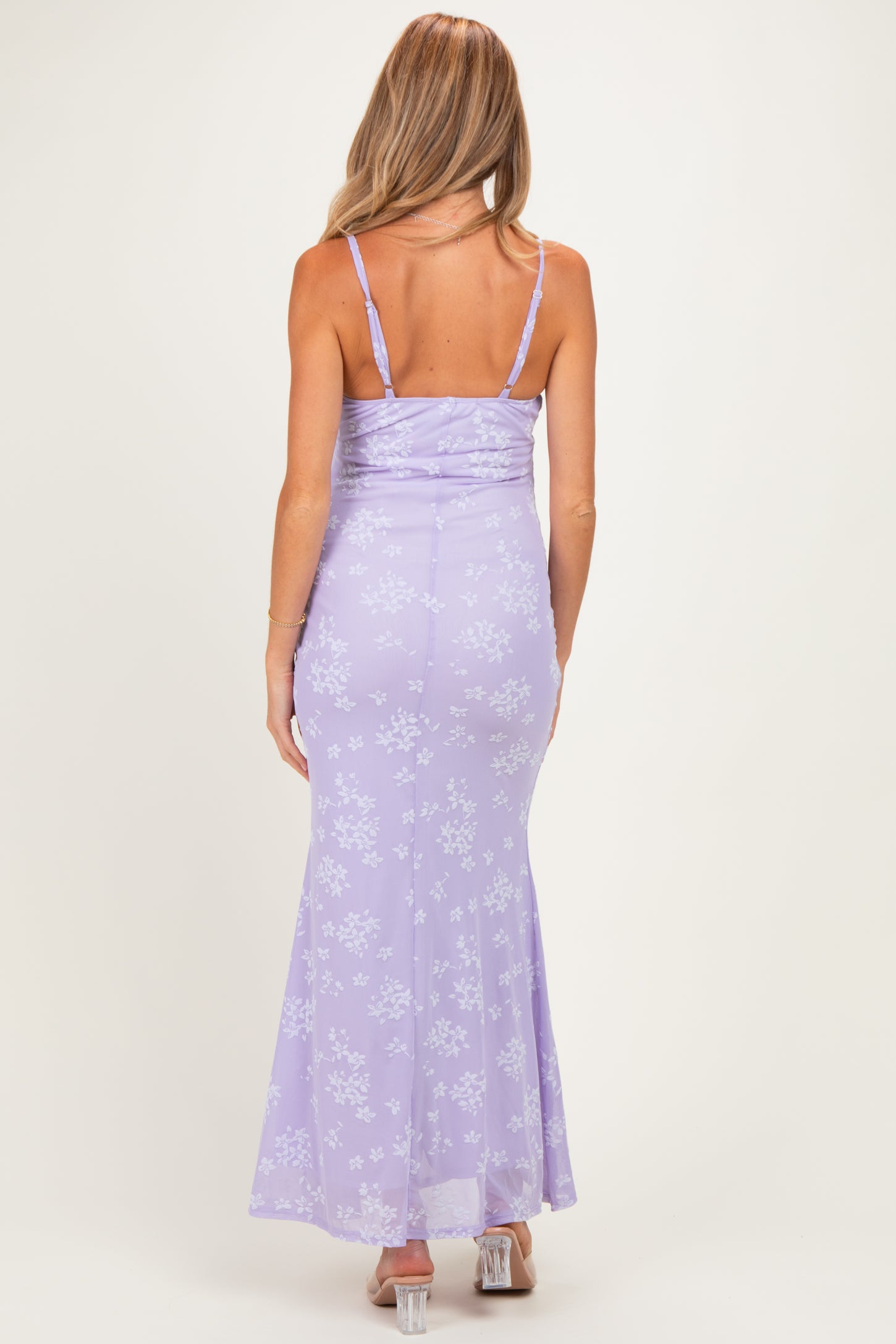 woman wearing a lavender floral print maternity dress with a fitted silhouette and adjustable spaghetti straps