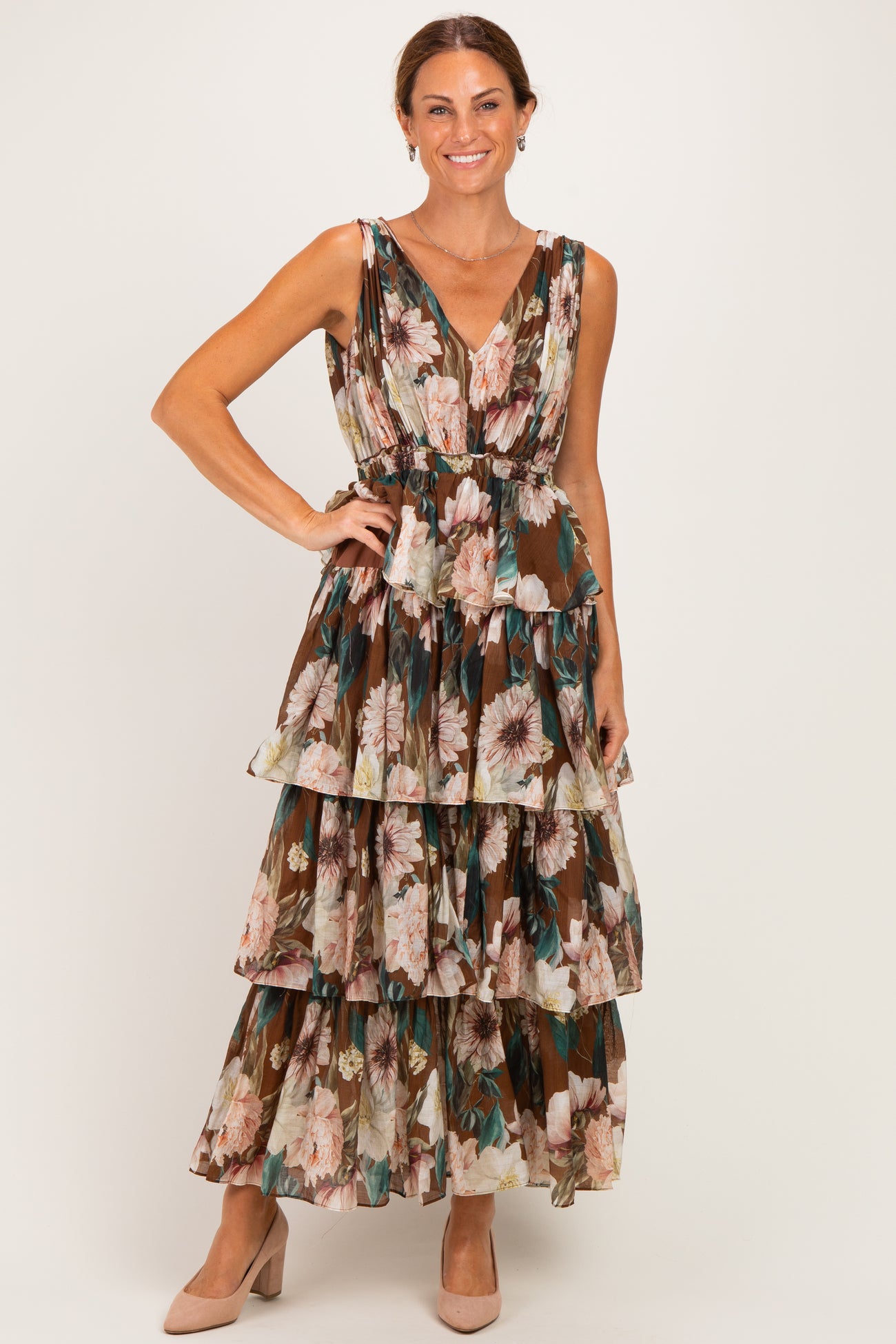 woman wearing a brown floral maxi dress with tiered ruffles and a v-neckline, styled with beige heels