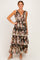 woman wearing a brown floral maxi dress with tiered ruffles and a v-neckline, styled with beige heels