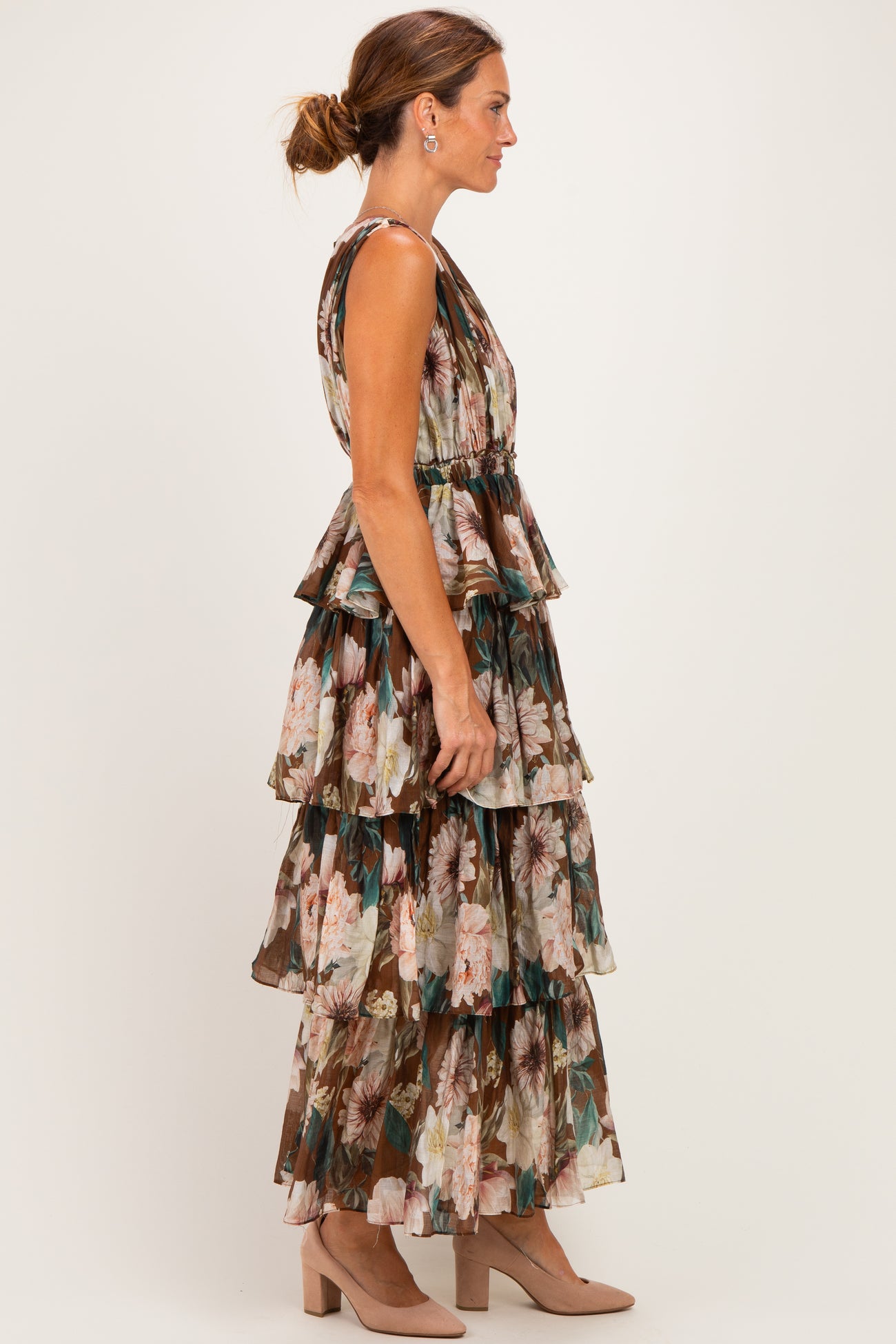 woman wearing a floral tiered maxi dress with a fitted bodice and flowy skirt, paired with beige block heels