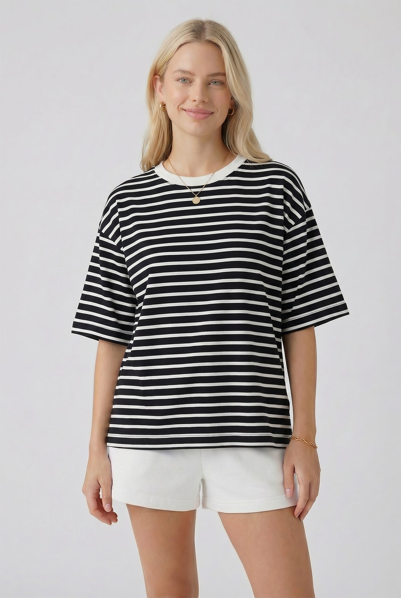 woman wearing a black and white striped oversized t-shirt paired with white shorts