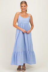 woman wearing a light blue striped maxi dress with a tiered bottom and spaghetti straps