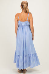 woman wearing a light blue striped maxi dress with spaghetti straps and a tiered ruffle hemline, viewed from the back