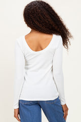 woman wearing a white long sleeve ribbed top with a scoop back and blue high-waisted jeans