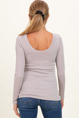 woman wearing a lavender ribbed long sleeve maternity top with a scooped back, styled with blue jeans
