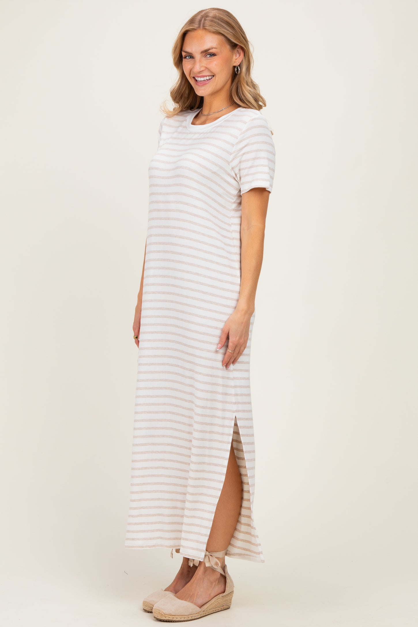 woman wearing a striped short sleeve maxi dress with side slits and a relaxed fit