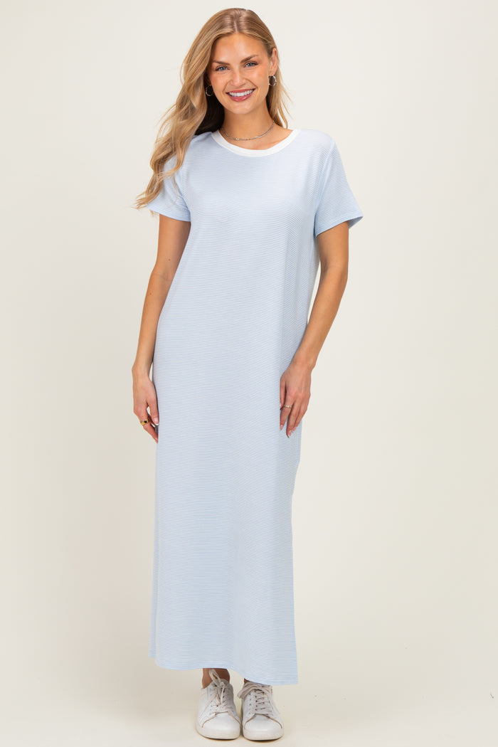 woman wearing a light blue short sleeve maxi dress paired with white sneakers
