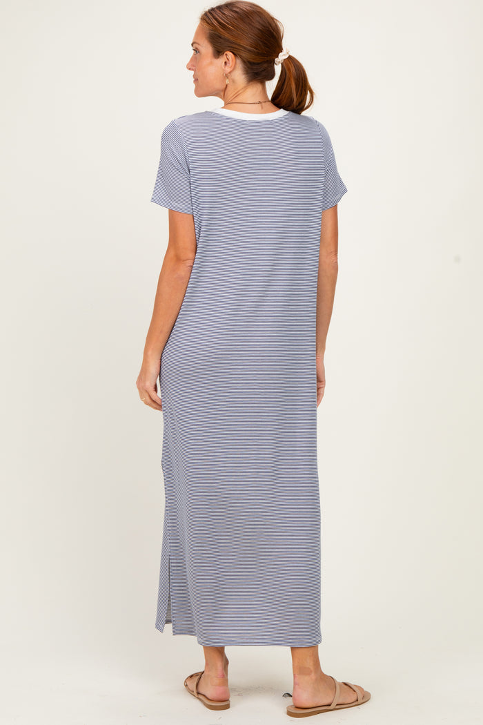 woman wearing a long light blue maxi dress with short sleeves and a slit, viewed from the back
