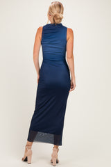 woman wearing a navy blue sleeveless maxi dress with a fitted silhouette and sheer bottom hem, shown from the back