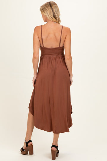 woman wearing a brown maternity midi dress with adjustable straps and a flowy skirt, showcasing her baby bump