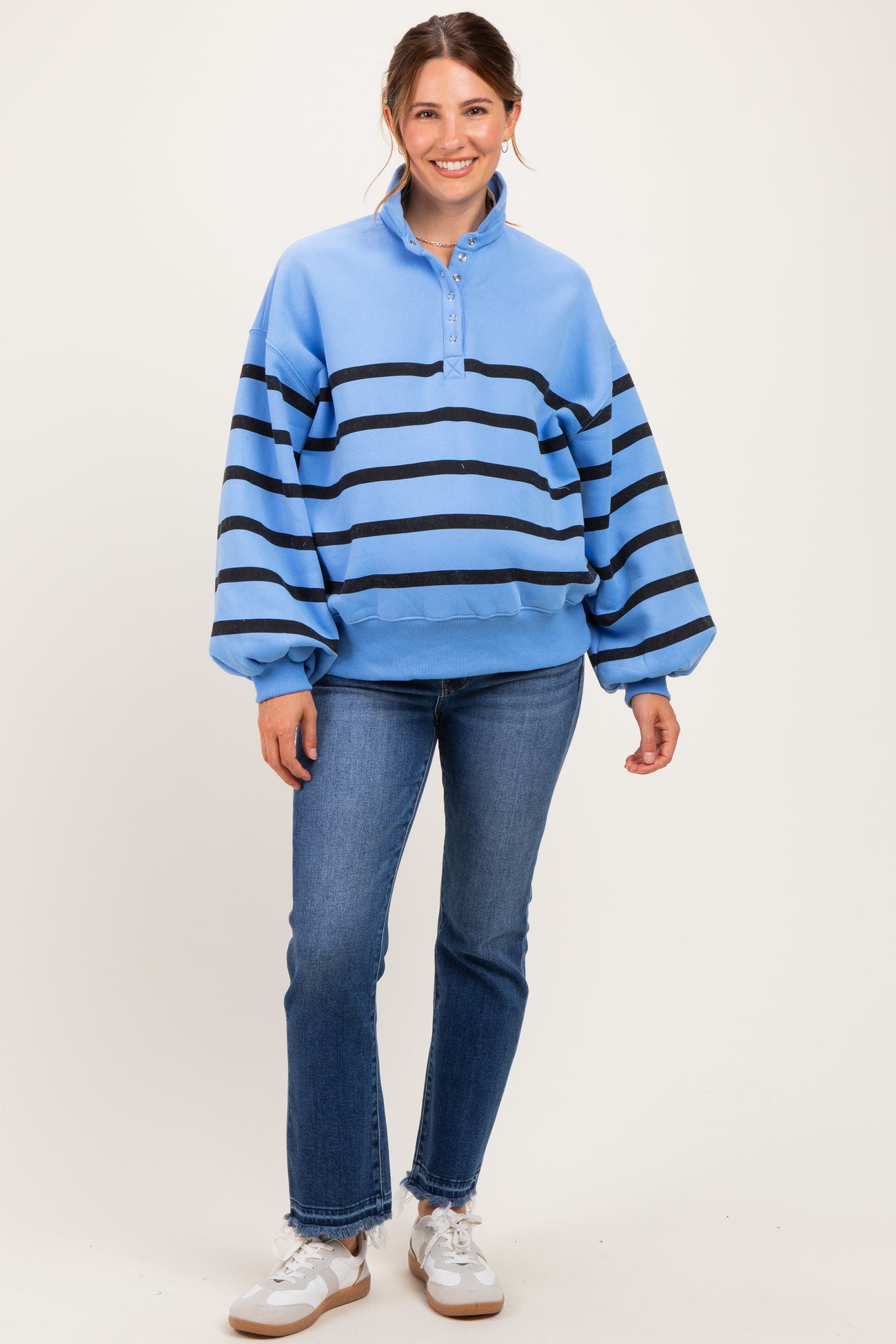 woman wearing a light blue striped maternity sweatshirt with a collar and balloon sleeves, paired with blue jeans