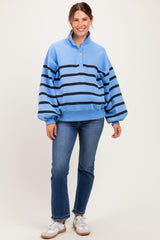 woman wearing a light blue striped maternity sweatshirt with a collar and balloon sleeves, paired with blue jeans