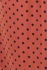 maternity wear in a rust-colored fabric with black polka dots
