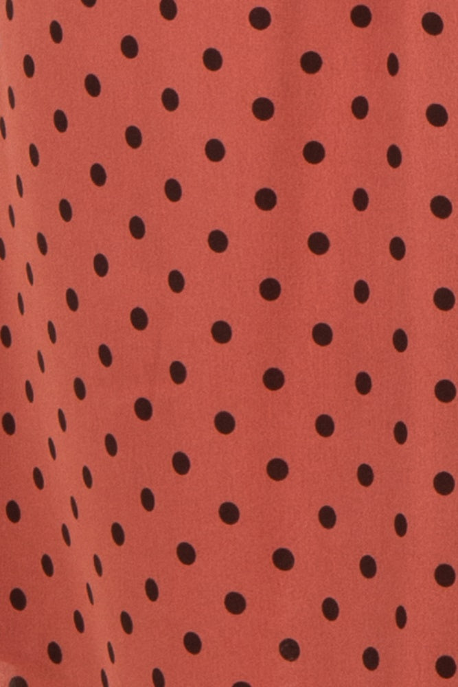 maternity wear in a rust-colored fabric with black polka dots