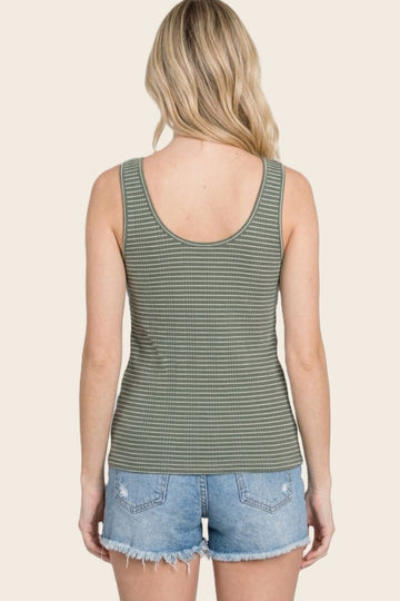 woman wearing a green and white striped tank top paired with denim shorts, viewed from the back