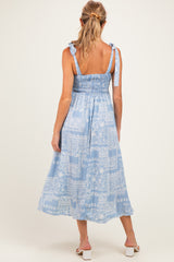 woman wearing a light blue maternity maxi dress with smocked bodice and tie straps, view from the back